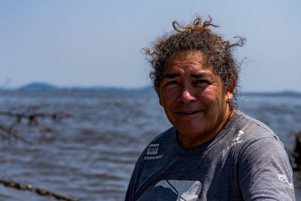 Mulher do projeto Uçá em close com mar ao fundo