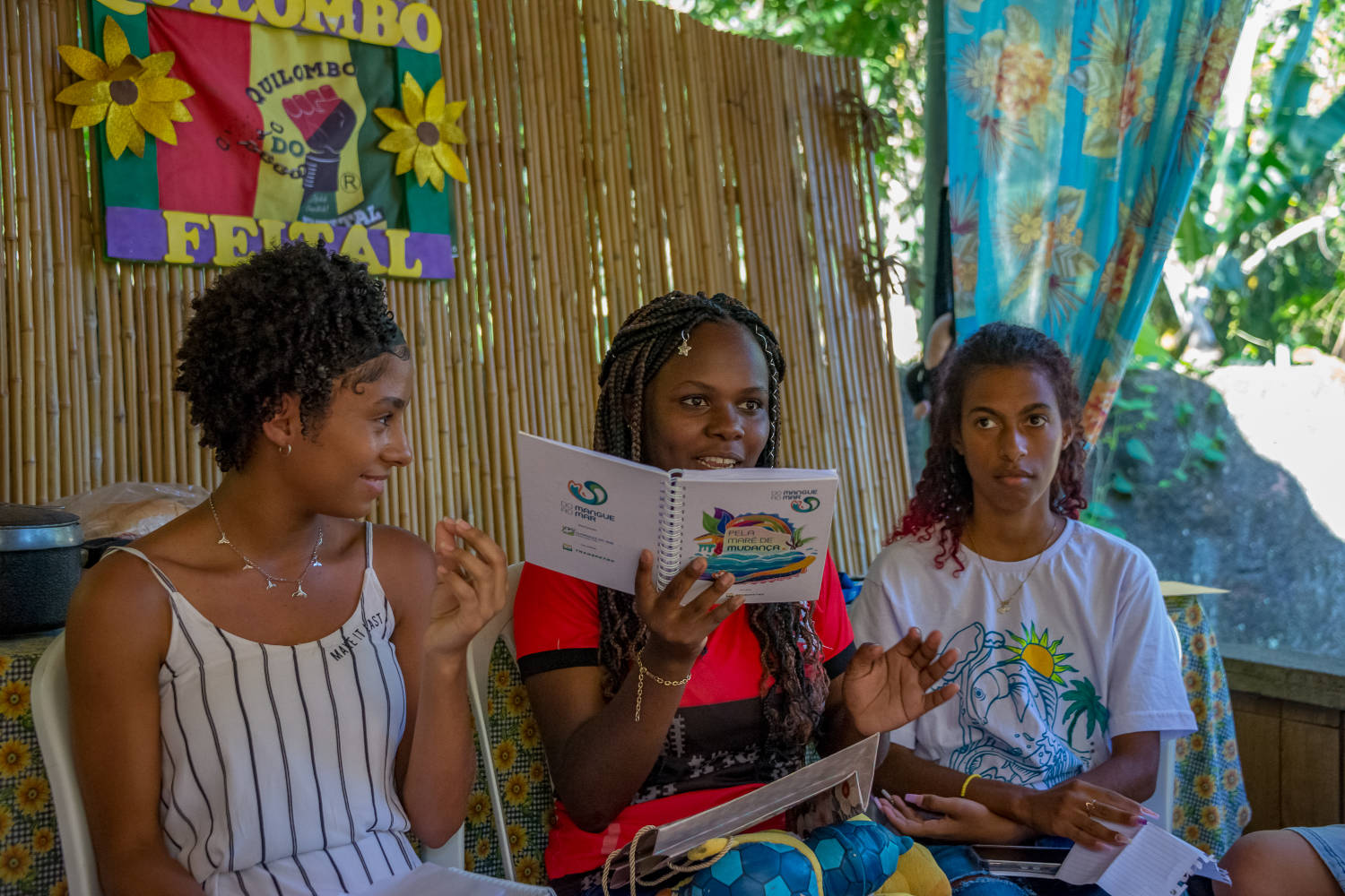 Três mulheres em quilombo, conversando