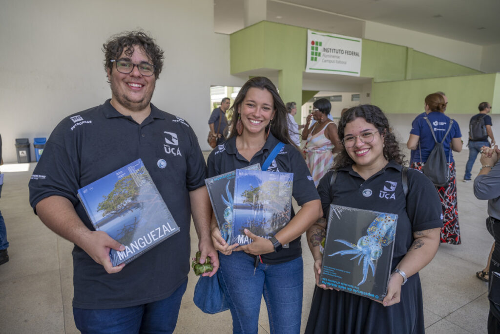 Participantes do evento segurando os livros